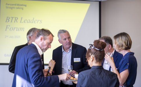 Speakers mingling in front of presentation board