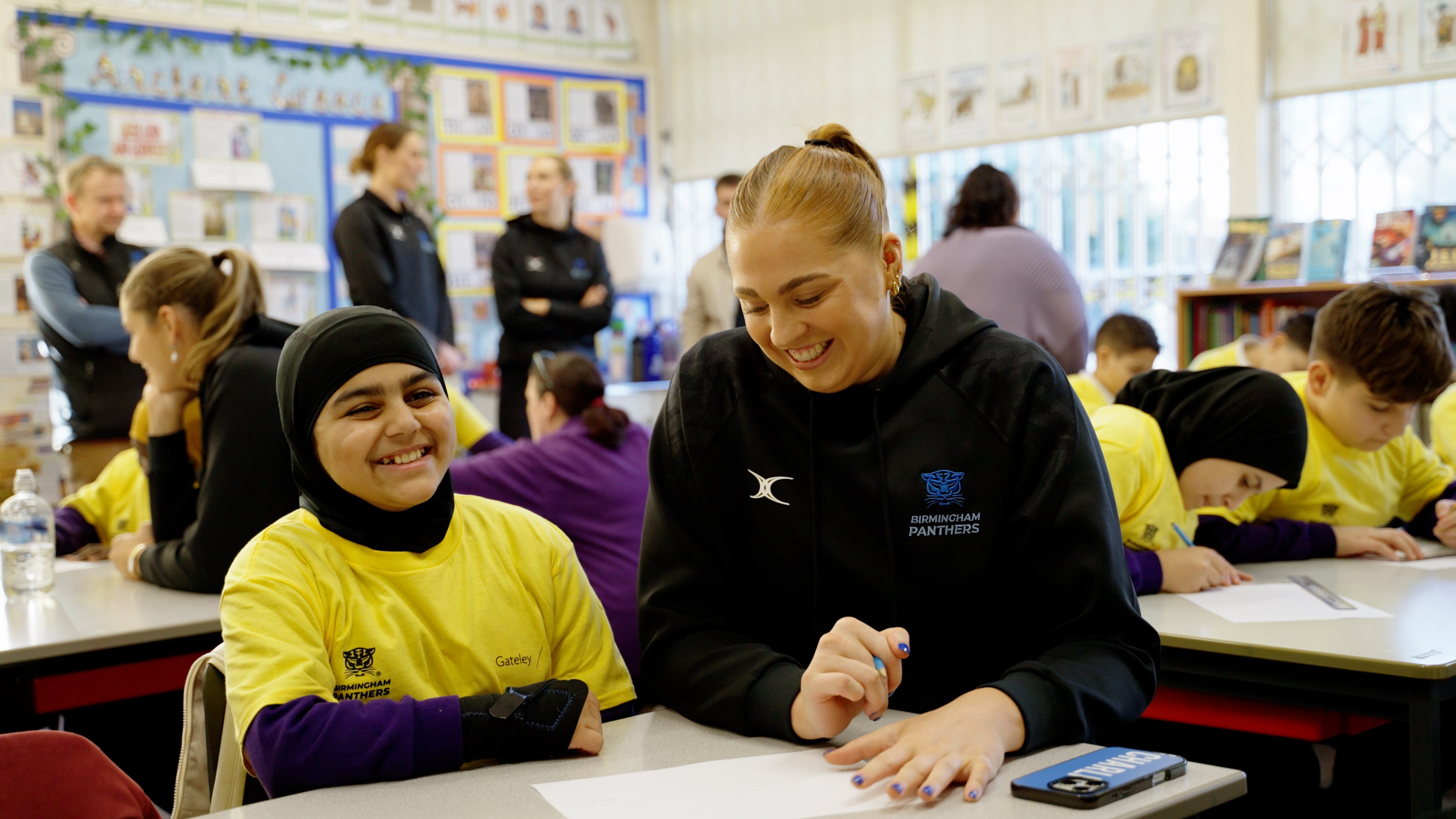 One of the players smiling with one of the children