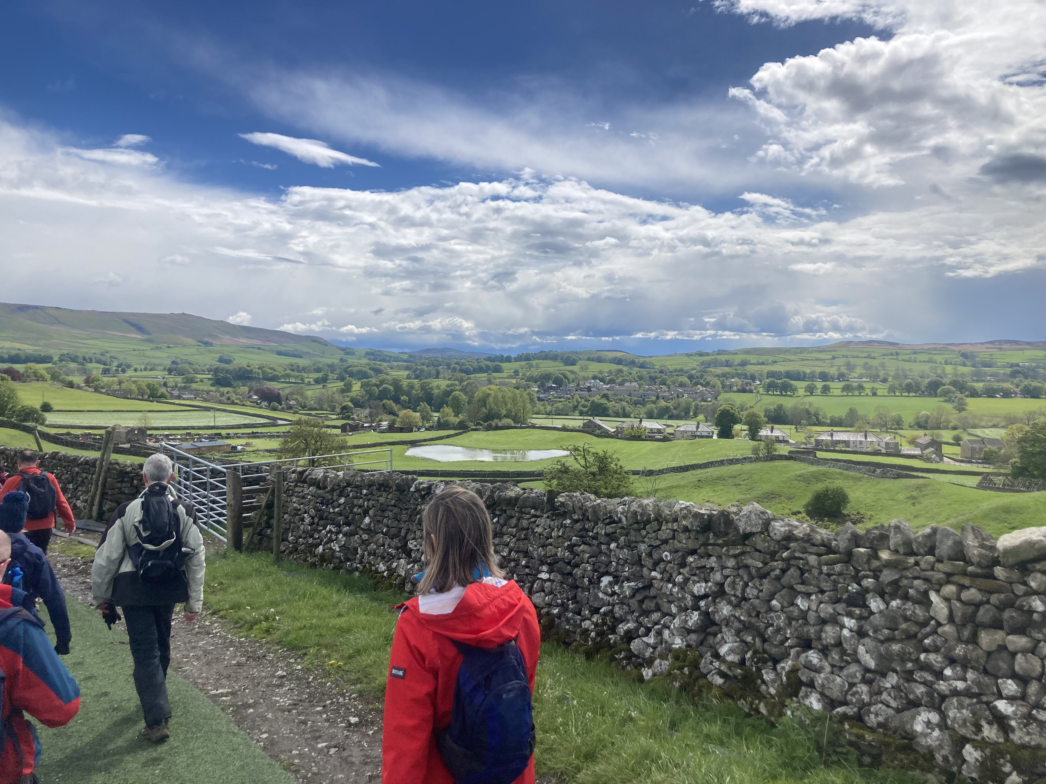 The team walking in the sun, the Yorkshire Dales behind them
