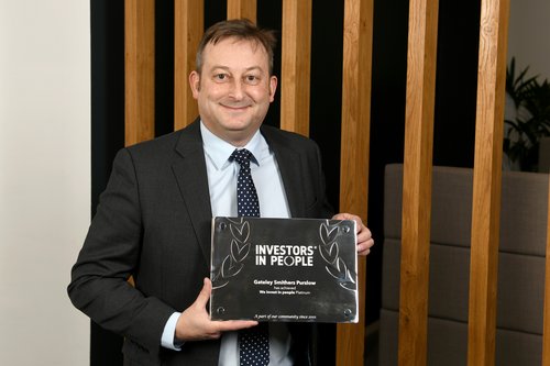Photo of Andrew Bussey holding IIP award