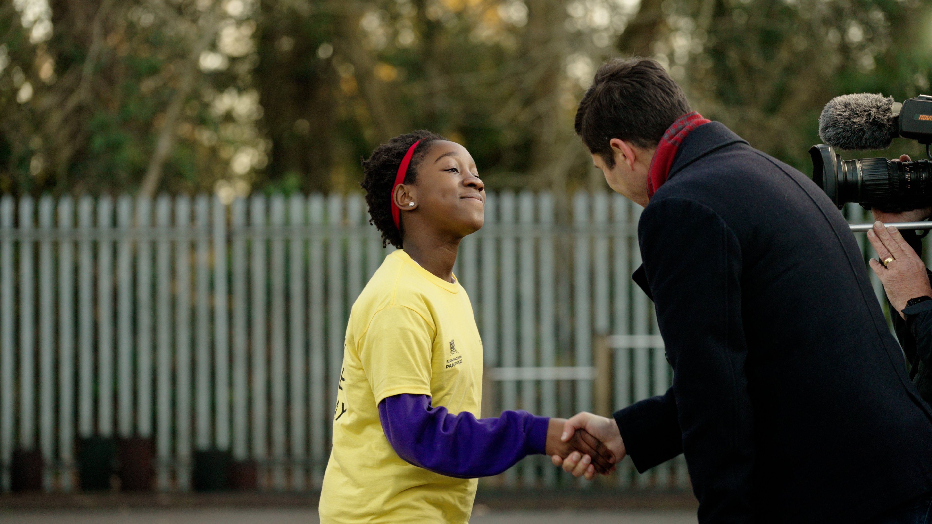 One of the children from the programme shaking the hand of a player