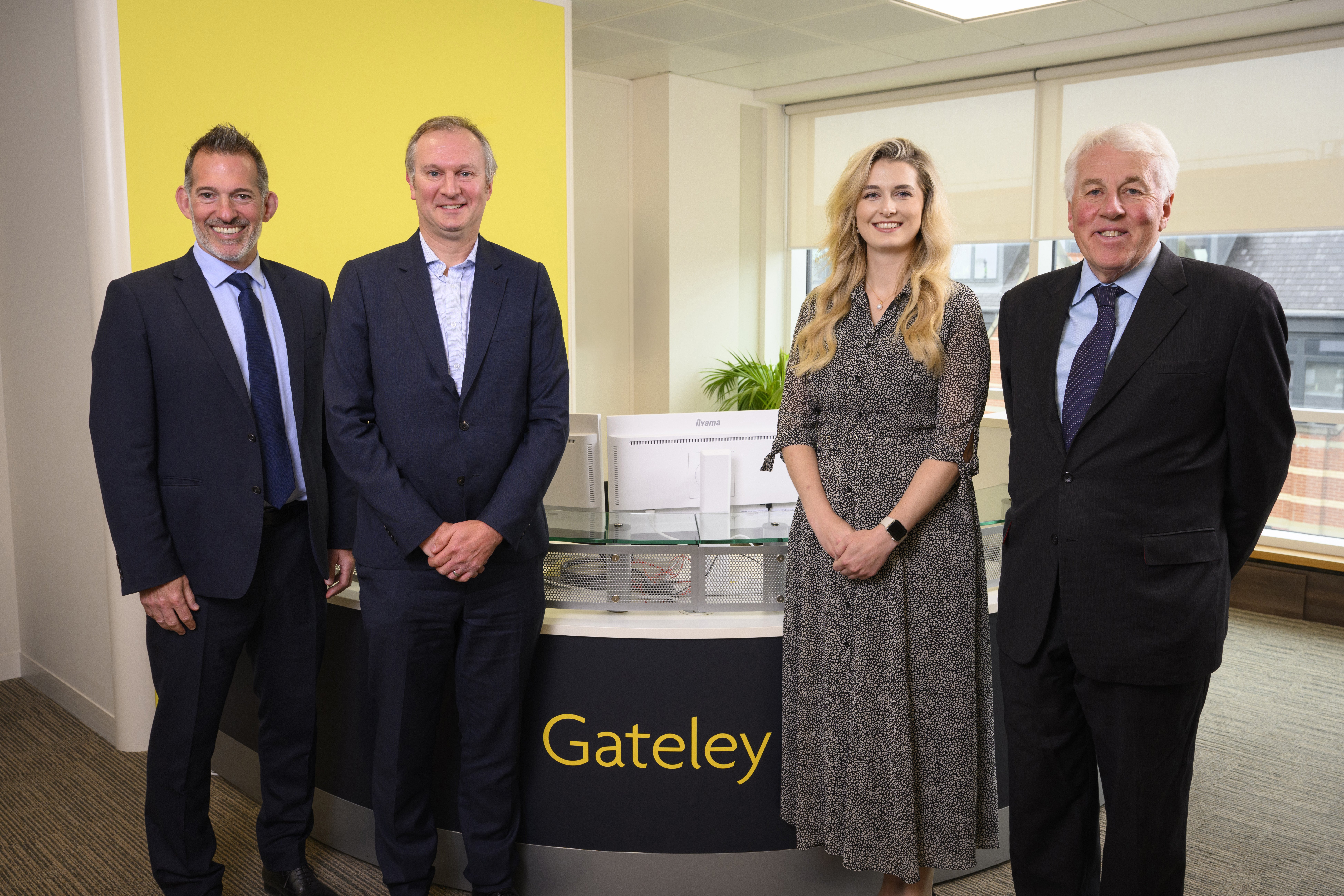 Gateley team smile in front of the reception desk at the Leeds office
