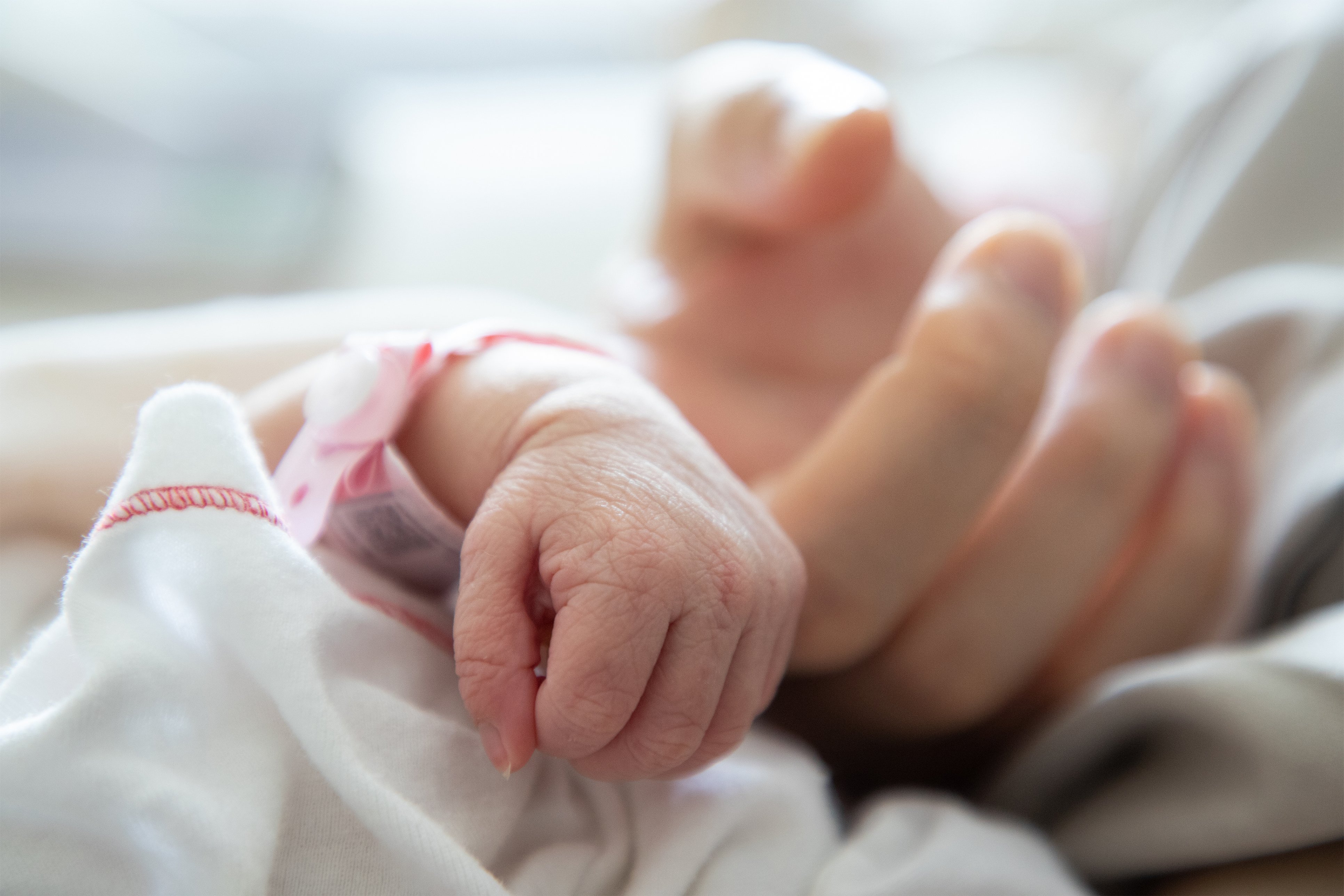 Photo showing newborn hand clutching adult finger