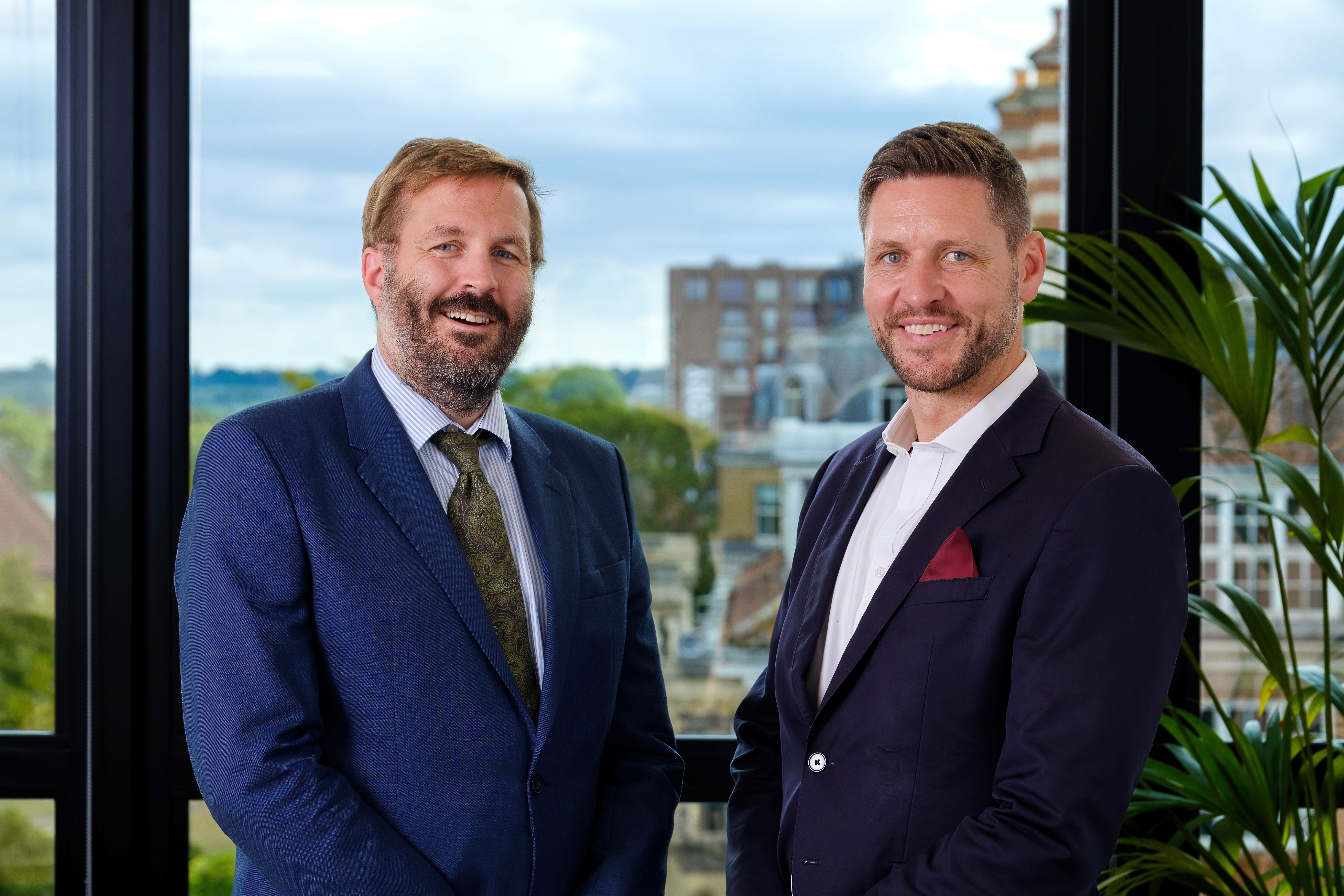 Brian Dowling and Andy Wilson smiling in front of office.