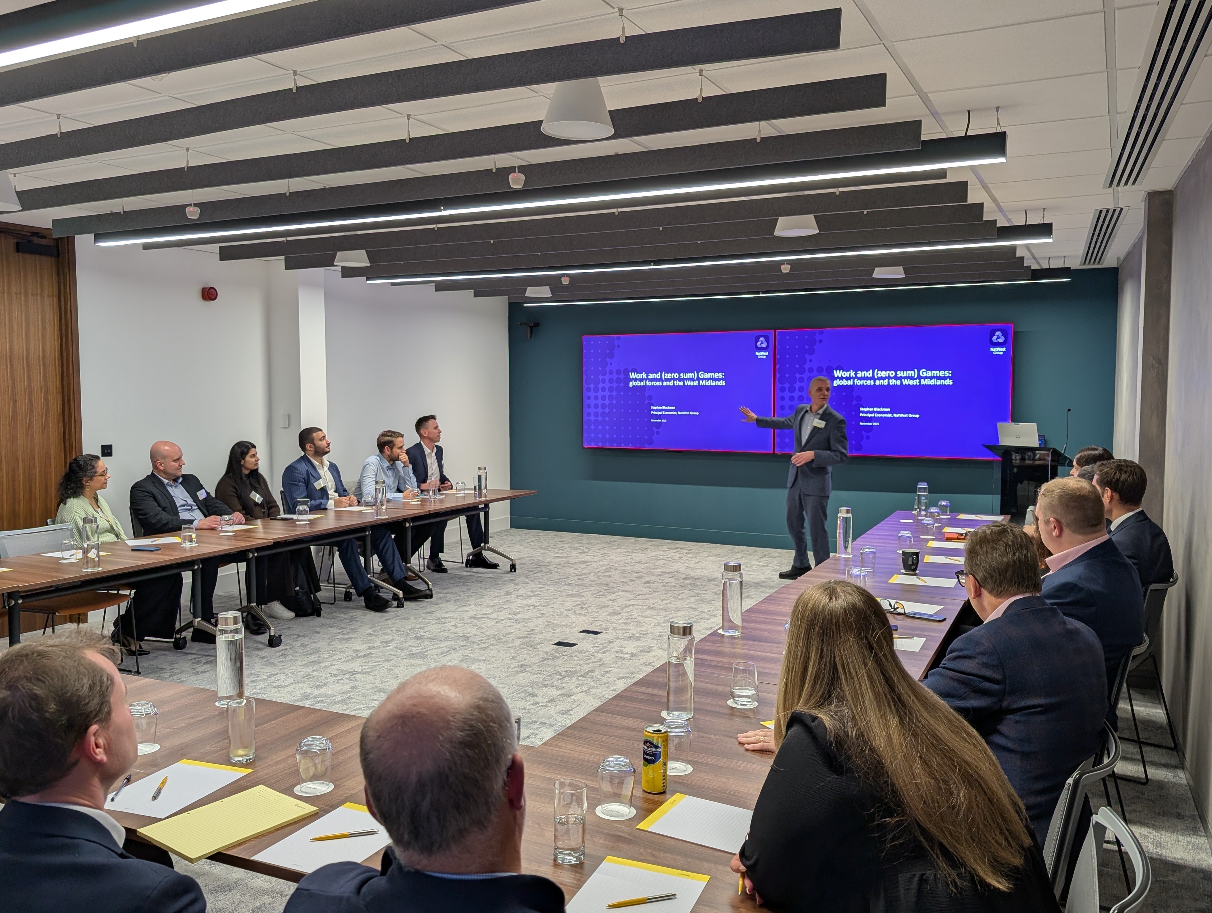 A speaker at the event addresses the room of attendees